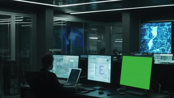 デスクトップコンピュータ上のデータセンターで3つのディスプレイ ソフトウェアとハードウェアを開発しているプロのItプログラマーのシルエット このディスプレイにはデータネットワークのアーキテクチャが表示されます 緑の画面 — ストック動画