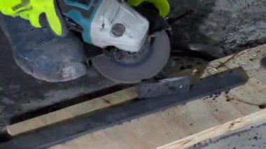 Bir endüstri işçisi metal bir aletle çalışıyor. Bir işçi, çeliği öğütüp parlatır. Öğütücü kıvılcımlar saçar..