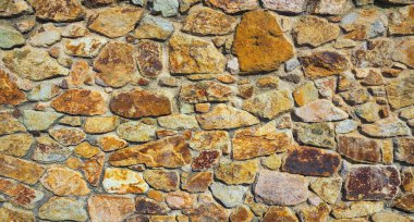 Arka plan ya da doku olarak doğal bir taş duvar parçası. Taş duvarın yapısı. Eski kale taşından duvar dokusu. Masonluk arkaplanı