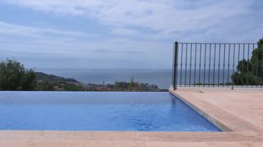 Turkuaz deniz manzaralı açık yüzme havuzundan göz kamaştırıcı bir manzara. Yaz tatili ve trave kavramı