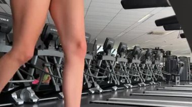 Koşu bandında koşan atletik kız spor yapıyor. 