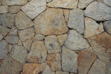 Duvara yakın, dekoratif taştan yapılmış, arka plan. Taş duvar örneği