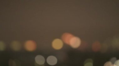 Gece şehrinde seçici bir odak noktası. Sıcak ton arka plan kavramına sahip soyut bulanık bokeh ışığı şehirde 