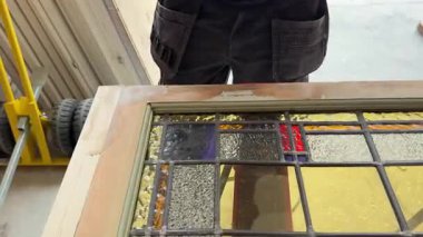 Zanaatkar, eski bir vitrini restore ediyor ahşap çerçeveye ahşap dolgu yapıyor. Yenileme, onarım ve işçilik kavramı