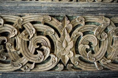 Çiçek desen ahşap arka planda, Tay tarzında oyulmuş.