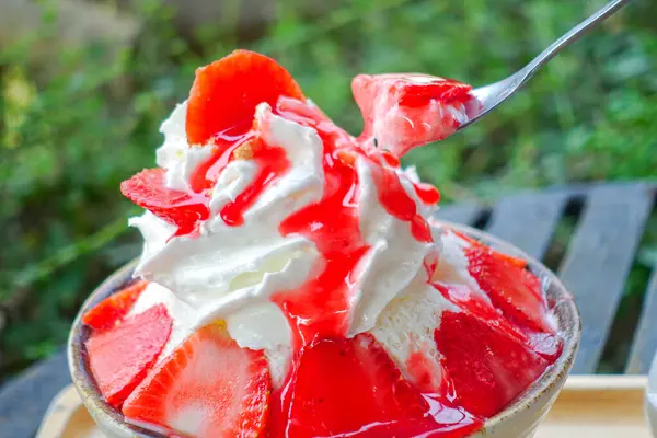 Çilekli Bingsu yanında çilek şurubu ve restorandaki masada taze çilek..