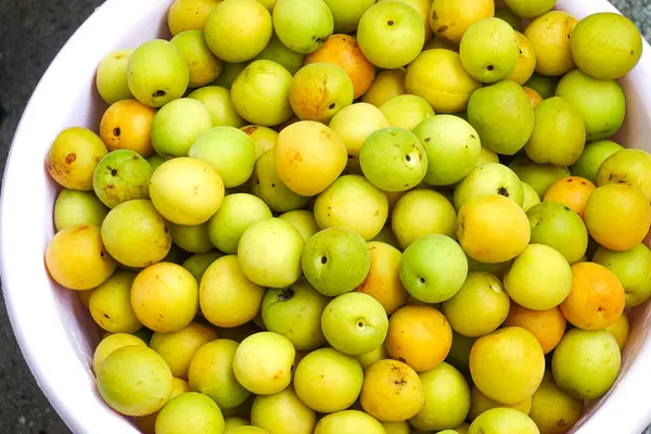 Yakın plan taze sarı erikler, açık yeşil erikler.