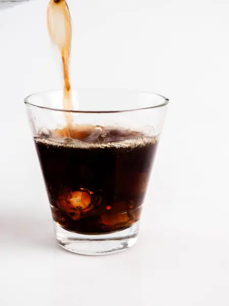 Beyaz Arkaplanda Buzlu Kola Dökülüyor.