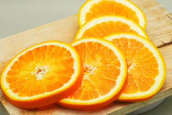 ahşap kesme tahtası üzerinde taze portakal dilimleri