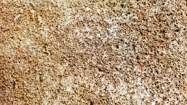 Sert ve organik dokulara sahip doğal bir kaya yüzeyinin yakın çekimi. Arkaplanda kullanmak için ideal tasarım ögeleri.