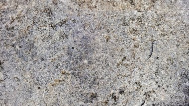 Sert ve organik dokulara sahip doğal bir kaya yüzeyinin yakın çekimi. Arkaplanda kullanmak için ideal tasarım ögeleri.