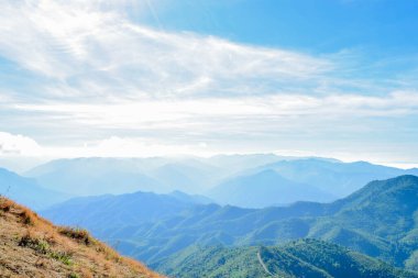 Mavi Gökyüzü ve Misty Hills Katmanları ile Manzaralı Dağ Manzarası