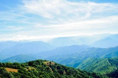 Mavi Gökyüzü ve Misty Hills Katmanları ile Manzaralı Dağ Manzarası