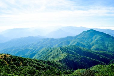 Mavi Gökyüzü ve Misty Hills Katmanları ile Manzaralı Dağ Manzarası