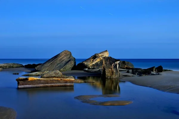 滨海岩石上美丽的自然景观与月光的长期照射 — 图库照片