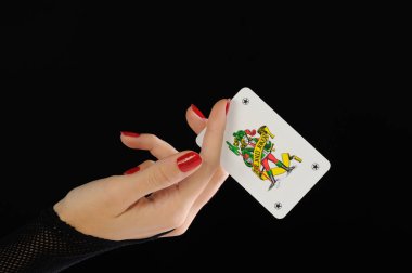 Güzel bir kadın poker fişleri ve siyah arka planda bir kartla el ele tutuşuyor.