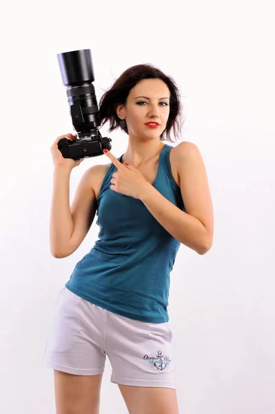beautiful young woman with a camera and a ball on a white background