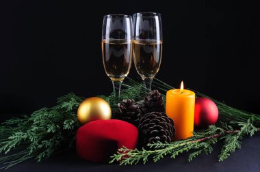 Yeni yıl süslemesi. İki kadeh şampanya ve siyah arka planda bir kadeh şarap.