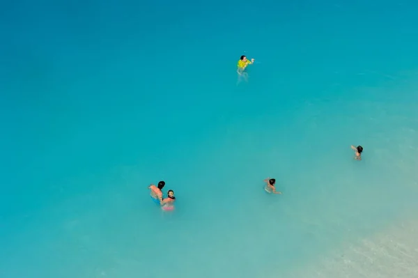 Türkiye 'nin Kaputas plajında mavi bayrak denizinde yüzen insanlar