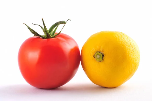 白色表面上的黄色柠檬和红色西红柿 — 图库照片