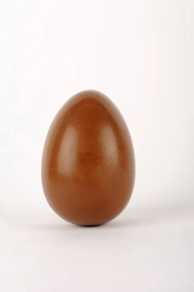 Σοκολατένιο Αυγό Λευκό Πιάτο Ελαφρύ Φόντο — Φωτογραφία Αρχείου