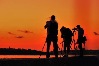 İstanbul akşam manzarasını altın saat ve görkemli gökyüzünü fotoğraflayan fotoğrafçıların siluetleri.
