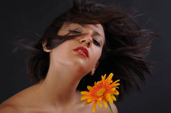 Siyah Arka Planda Turuncu Kasımpatı Tutan Güzel Bir Kızın Portresi — Stok fotoğraf