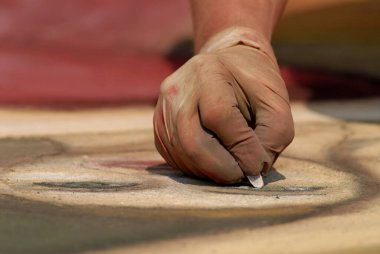 Sanatçı el, Madonnari festivaline katılırken yumuşak pastel tebeşirle sokakta güzel sanat eserleri yapıyor.