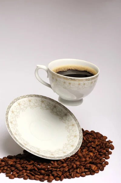 stock image hot coffee and coffee beans in a cup levitation on a white background