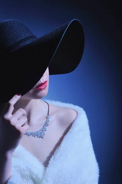 身穿白色长袍 头戴黑色帽子 戴钻石项链 戴着黑色背景手镯的漂亮女人 — 图库照片