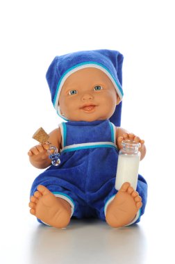 Mavi tulumlu ve beyaz arka planda süt şişesi olan sevimli erkek bebek..