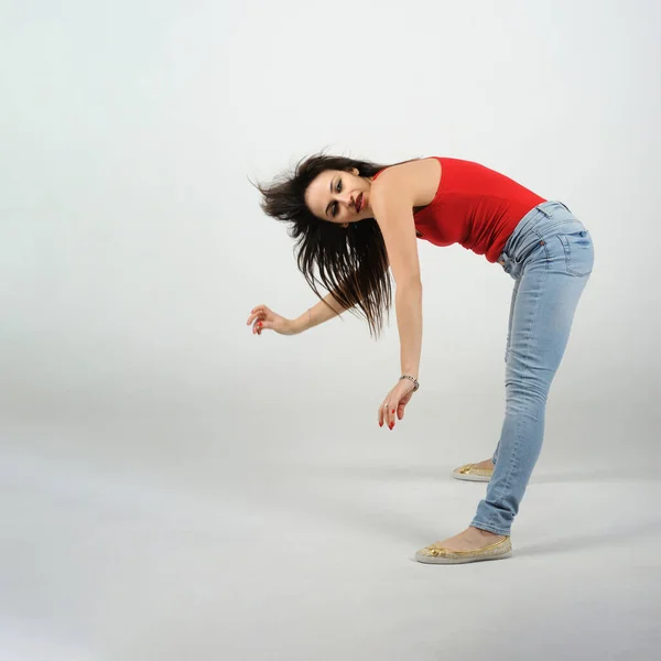 Giovane Bella Ballerina Posa Sfondo Studio Shirt Rossa Jeans Appoggiata — Foto Stock