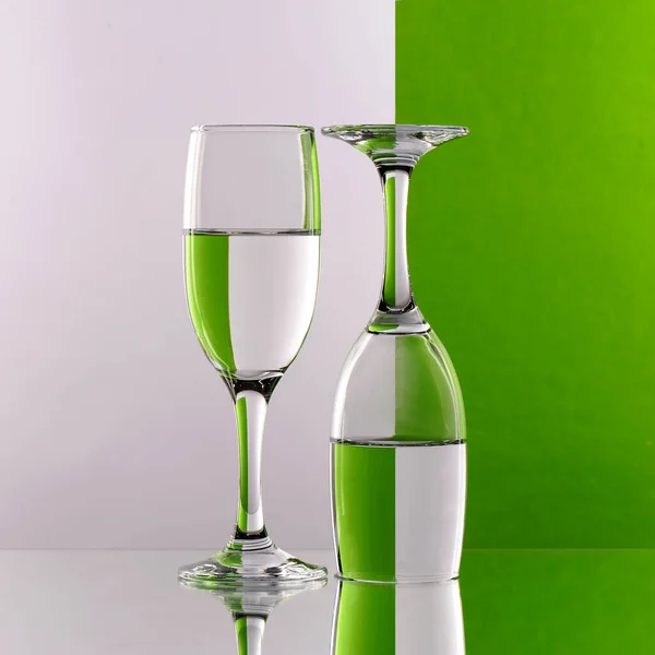 Glass Goblets Water Them One Straight Other Inverted Fragmented Green — Stock Photo, Image