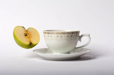Beyaz arka planda bir fincan çay ve elma. İzole edilmiş