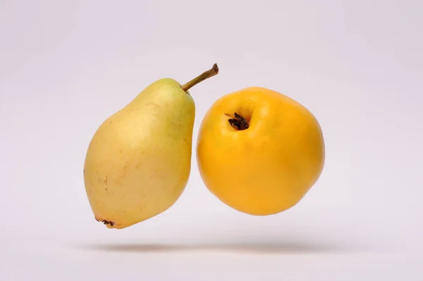 yellow pear and yellow quince on a white background, close-up