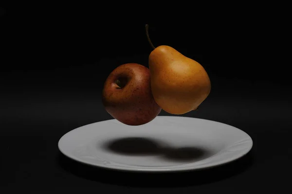 梨子和苹果漂浮在黑色背景的瓷盘上 — 图库照片