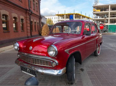 Minsk, Belarus. 15 Ekim 2023 Retro aracı Moskvich 407 tarihi itfaiye binasının yanında, ön manzara