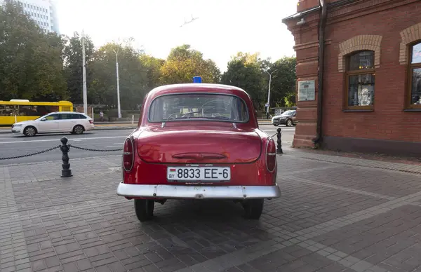 Minsk, Belarus. 15 Ekim 2023 Retro aracı Moskvich 407 tarihi itfaiye binası yakınında, dikiz manzaralı.