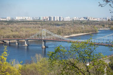 İlkbaharda Kyiv 'deki Dinyeper Nehri üzerindeki yaya köprüsü.