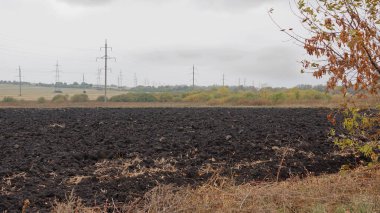 A plowed field on a cloudy autumn day clipart