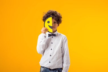 İki kağıt parçasında mutlu ve üzgün suratlar tutan üzgün çocuk. simge.