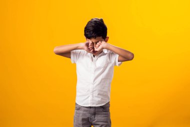 Sarı arka planda üzgün çocuk portresi. Duygular ve zorbalık kavramı