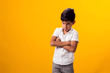 Sarı arka planda üzgün çocuk portresi. Duygular ve zorbalık kavramı