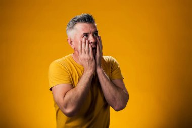 Şaşırmış bir adamın elleriyle yüzüne dokunuşunun portresi. İnsanlar ve duygu kavramı 