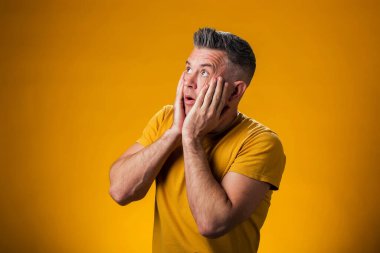 Heyecanlı ya da şaşırmış bir adamın portresi. İki eli de suratında. İnsanlar ve duygu kavramı