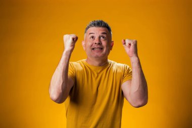 Mutlu adamın portresi, kazanan hareketi elleriyle gösteriyor. Hedef başarı konsepti