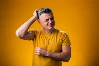 İnsan portresi şaşırtır ve soru sormayı merak eder. Sarı arka plan üzerinde kafa kafaya düşünmek. Düşünceli kavram.