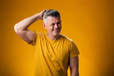 İnsan portresi şaşırtır ve soru sormayı merak eder. Sarı arka plan üzerinde kafa kafaya düşünmek. Düşünceli kavram.