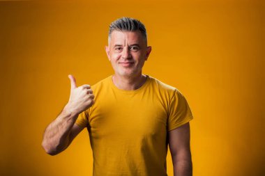 Tek eliyle sarı arka planda baş parmağı olan bir adamın portresi. İnsanlar ve duygu kavramı