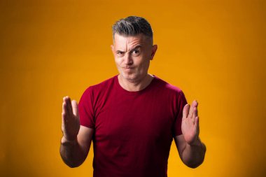 Büyük ve büyük boyut işareti gösteren el hareketleriyle insan portresi, sarı arkaplan üzerinde ölçü sembolü 